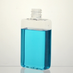 正方形のプラスチックボトルポンプが付いている空のローションボトル